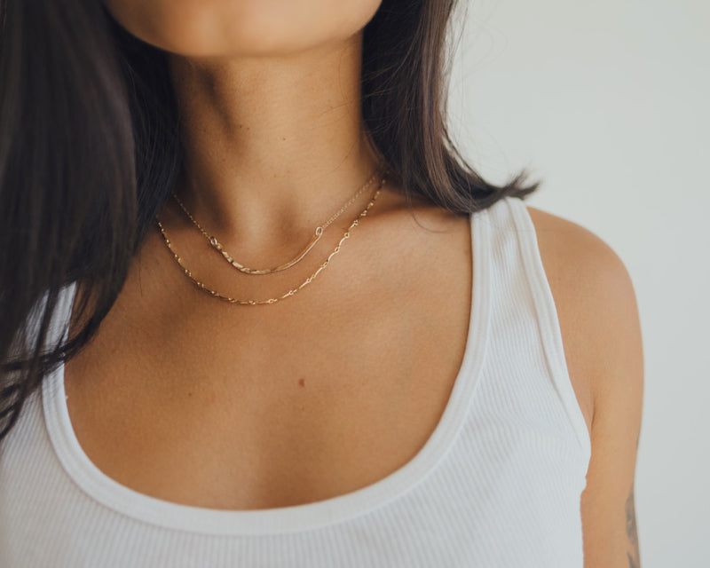 Our model wearing the gold curved bar necklace